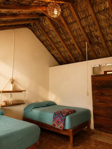 a bedroom with two beds and a wooden ceiling at Siete Mares in Guayabas