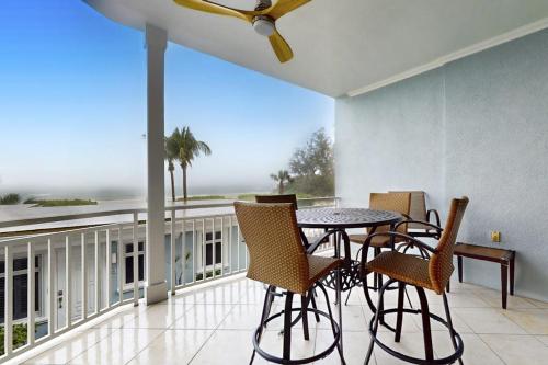 a balcony with a table and chairs and a large window at Palm Gables 106 in Holmes Beach
