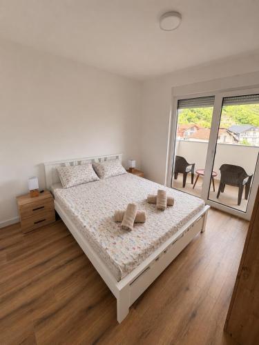 ein weißes Schlafzimmer mit einem großen Bett und zwei Kissen in der Unterkunft Apartment EDA in Bosanska Krupa