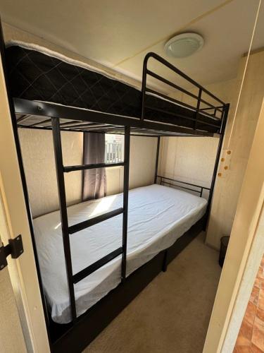 a bedroom with two bunk beds in a room at Sweet Caravan - Hemsby in Hemsby