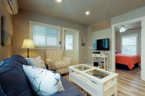 a living room with a blue couch and a bedroom at South Bay Inn 1 in Anna Maria