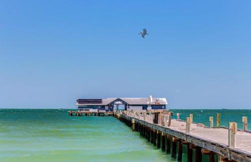 a pier with a building on top of the water at Gertie's Lime House in Holmes Beach
