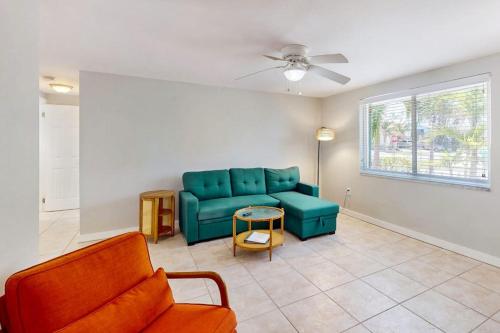 a living room with a blue couch and a window at Gertie's Lime House in Holmes Beach