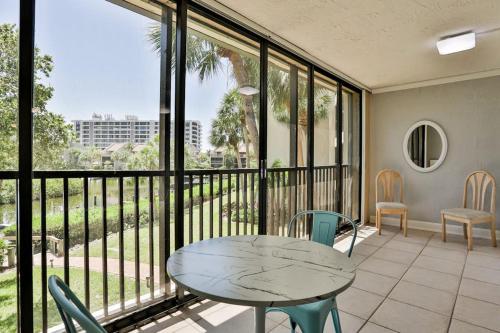 a room with a table and chairs and a balcony at Midnight Cove II 823 in Siesta Key