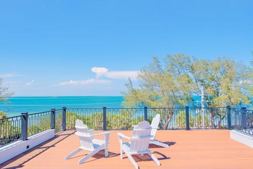 two chairs and a table on a deck overlooking the ocean at Gulf View Estate in Anna Maria