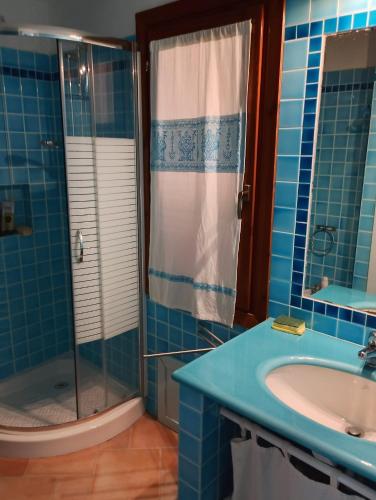 a blue bathroom with a sink and a shower at Villa Paradiso holidays in Costa Paradiso