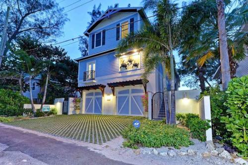a blue house with a garage and a palm tree at Wine Down in Ilexhurst