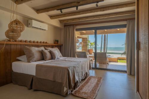 a bedroom with a bed with a view of the ocean at Aqua de Mar Condo Hotel in Icaraí