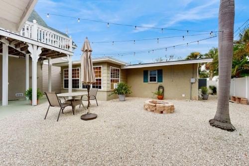 a patio with a table and an umbrella in front of a house at Mint Green Getaway in Holmes Beach