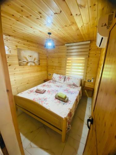 a bedroom with a bed in a wooden room at Guest House Castle in Koman