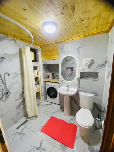 a bathroom with a toilet and a shower and a sink at Guest House Castle in Koman