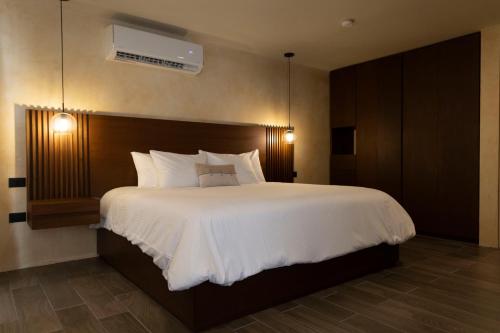 a bedroom with a large bed with white sheets and pillows at Moreira Hotel Boutique in Mérida