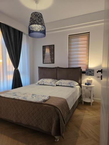 a bedroom with a bed and a chandelier at Cozy Central Home & Free Private Parking in Craiova