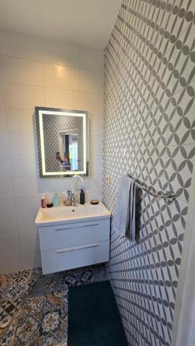 a bathroom with a sink and a mirror at CANj LOUNGE STUDIO in Čanj