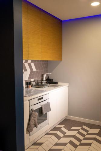 a kitchen with white cabinets and a stove top oven at Apartament Augustów SWAN in Augustów
