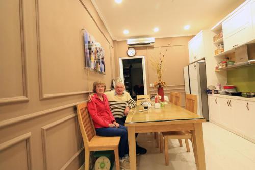 a man and woman sitting at a table in a kitchen at Tung Trang Hotel in Hanoi