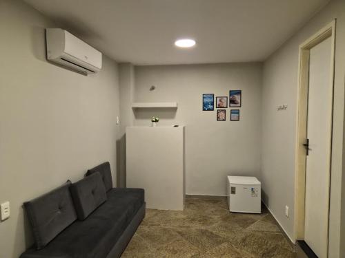 a living room with a couch and a refrigerator at CaisSuites in Cabo Frio
