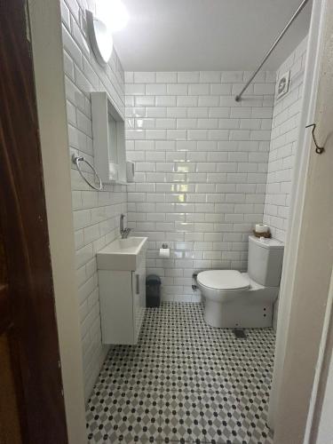 a white bathroom with a toilet and a sink at Ayvalık 1892 Konukevi in Ayvalık