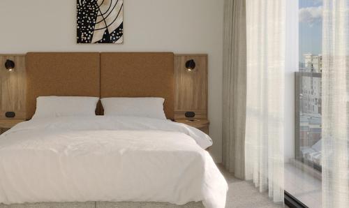 a bedroom with a large white bed and a window at Quest on Wickham Terrace in Brisbane