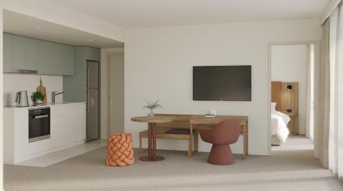 a kitchen with a table and a tv on a wall at Quest on Wickham Terrace in Brisbane