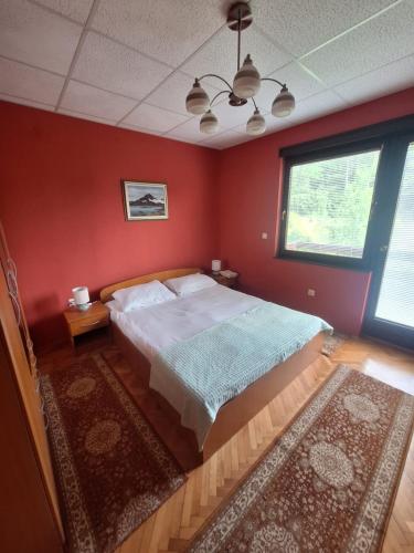 a bedroom with a large bed in a red wall at Villa Tira in Jajce