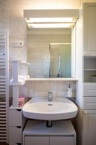 a bathroom with a sink and a mirror at Entire Villa for 6 near Bled -Private Garden, Grill & Free Parking in Lesce