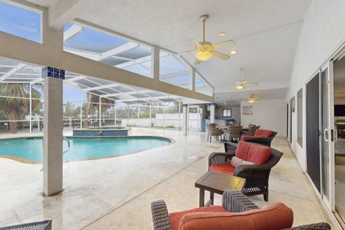 a living room with a pool and chairs and a ceiling at Anna Maria's Finest in Anna Maria
