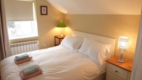 a bedroom with a white bed with a window at Eastern Lodge 11B in Lymington