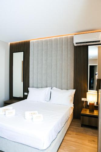 a bedroom with a large bed with two white towels on it at Oribu Boutique Hotel Vlore in Vlorë