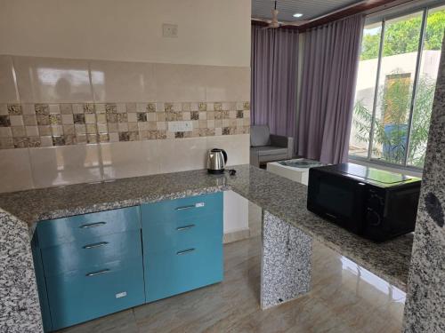 a kitchen with blue cabinets and a counter top at Kohli Farms in Gof