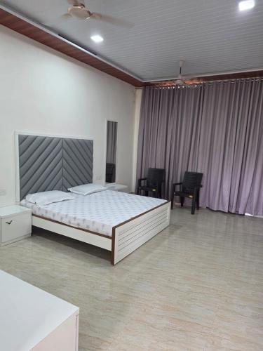 a bedroom with a bed and chairs in it at Kohli Farms in Gof