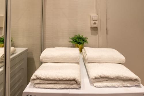 a pile of towels sitting on a counter in a bathroom at Cœur de Fontainebleau in Fontainebleau