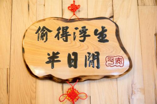 un panneau en bois avec des écrits chinois sur un mur dans l'établissement Free Time B&B, à Taïtung
