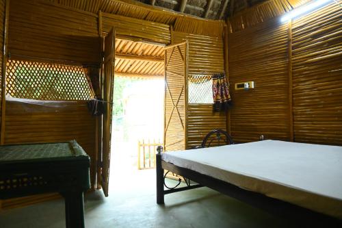 a bedroom with a bed in a wooden room at Bagan Bilas Homestay in Jhilimili