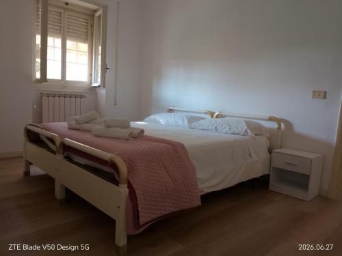 a bedroom with a white bed with a red blanket at FLOWER-House in Anzio