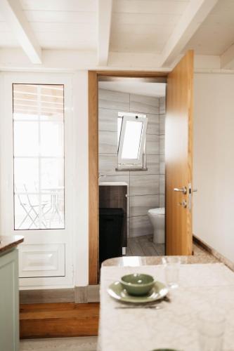 a bathroom with a toilet and a door with a plate on a counter at Casa do Foral by Lethes Legacy in Ponte de Lima