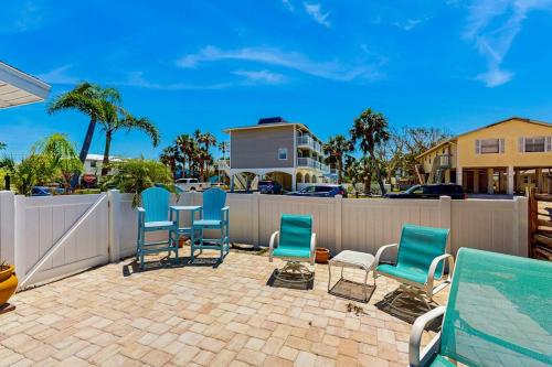 a patio with chairs and a table and a fence at Gertie's Coconut House in Holmes Beach