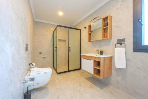 a bathroom with a shower and a toilet and a sink at Villa A1 Canpare in Fethiye