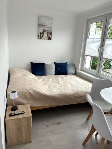 a bedroom with a bed with blue pillows and a table at Błękitna Fala in Ustka