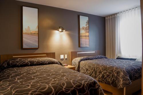 une chambre d'hôtel avec deux lits et une fenêtre dans l'établissement Complexe Hotelier Le 55, à Bécancour