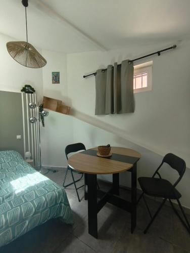 a room with a table and chairs and a bed at Cozy studio - proche Cité de Carcassonne in Couffoulens