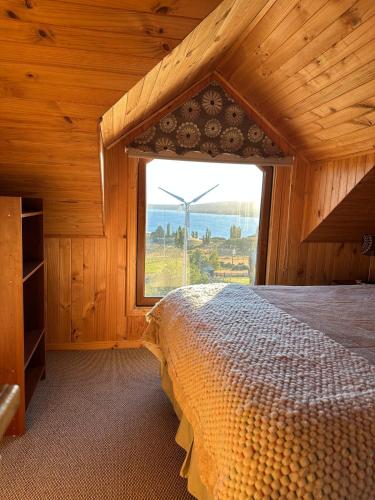 a bedroom with a bed and a large window at Casa Quento in Castro