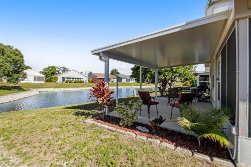 a house with a covered porch with chairs and a pool at Bella Villa in Bradenton