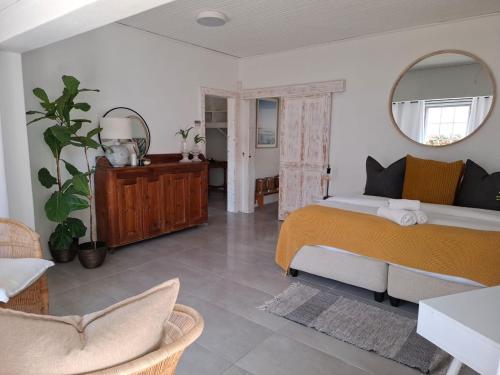 a bedroom with a bed and a mirror at Little Tara Cottage in Hermanus