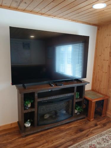 a living room with a fireplace and a flat screen tv at Back Bay Getaway in Hayward