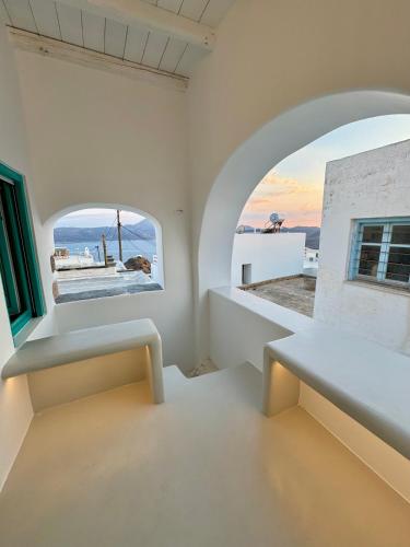 a white room with a window and a bench at Plaka Suites in Plaka Milou