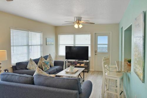 a living room with a couch and a tv at Bungalow A in Bradenton Beach