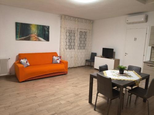 a living room with an orange couch and a table at Lary&Giù in Cadelbosco di Sopra
