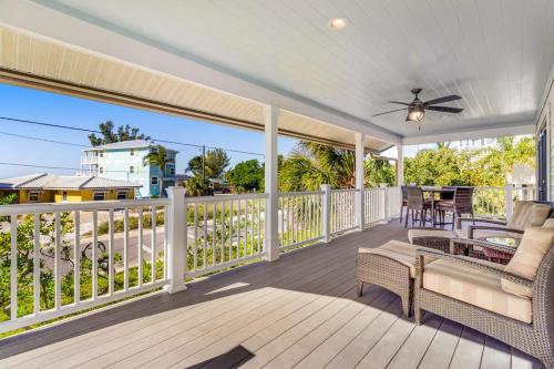 a porch with a couch and chairs on a deck at Sundance Cottage in Anna Maria
