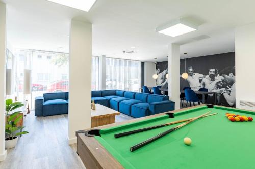 a living room with a pool table and blue couches at ABeleven in Aberdeen